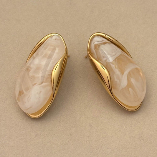 White marble-effect resin oval earrings with gold-toned frames, side view pair