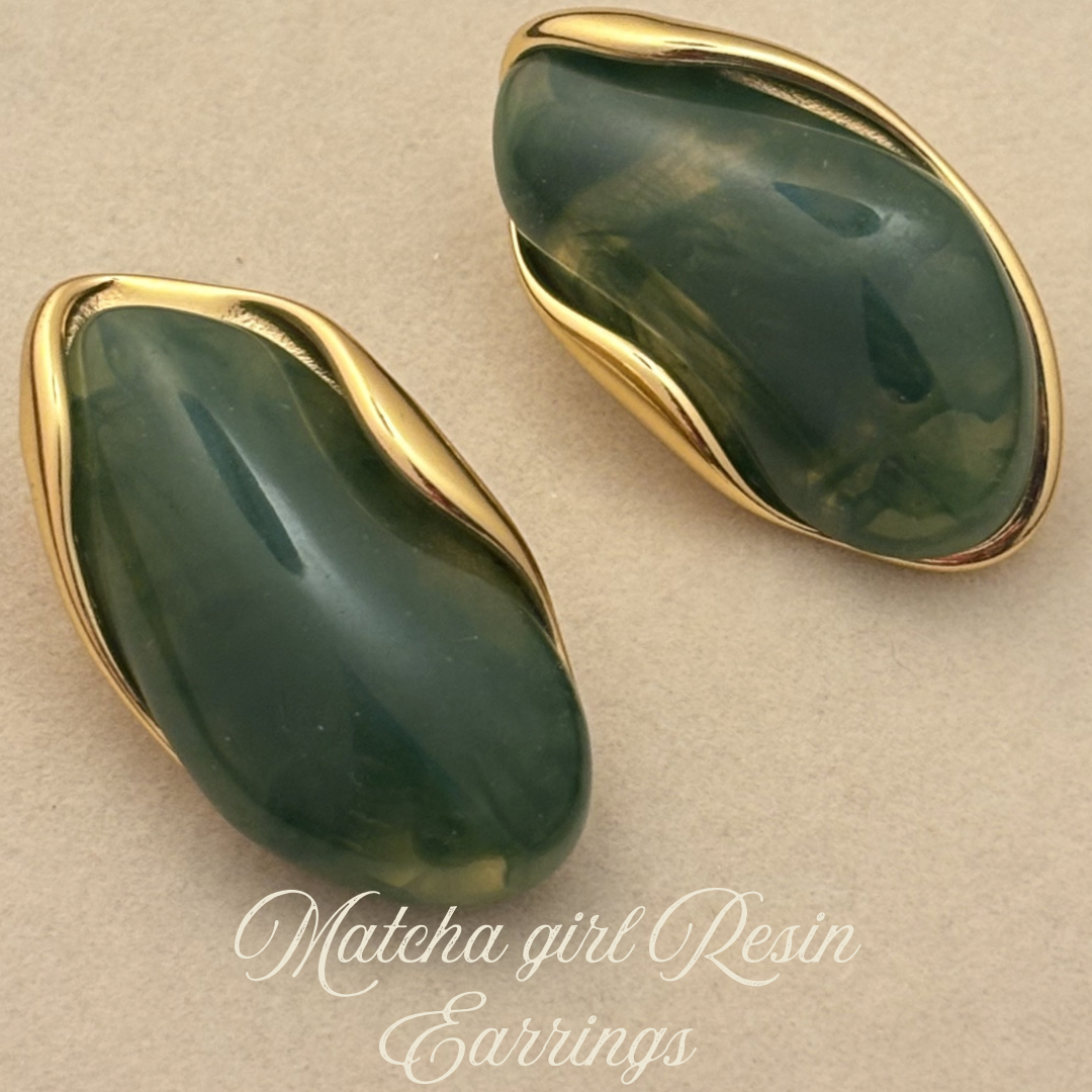 Green resin teardrop earrings with gold-tone edges, angled close-up