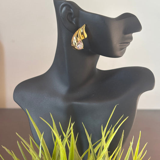 Gold teardrop earrings with clear crystal, worn on mannequin