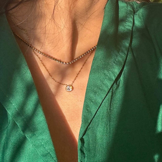 Gold layered tennis necklace with pavé center charm and short beaded chain