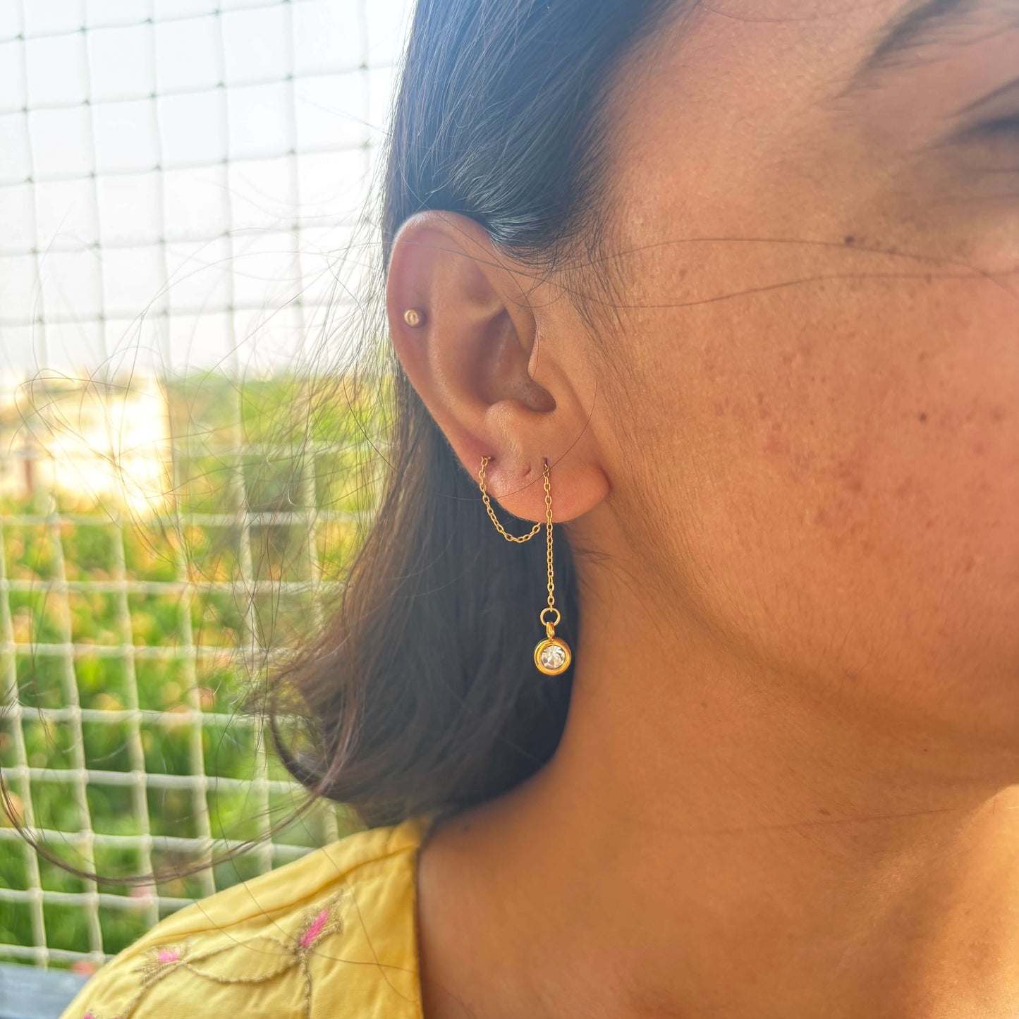 Gold threader drop earring with round crystal charm, long chain dangling from ear