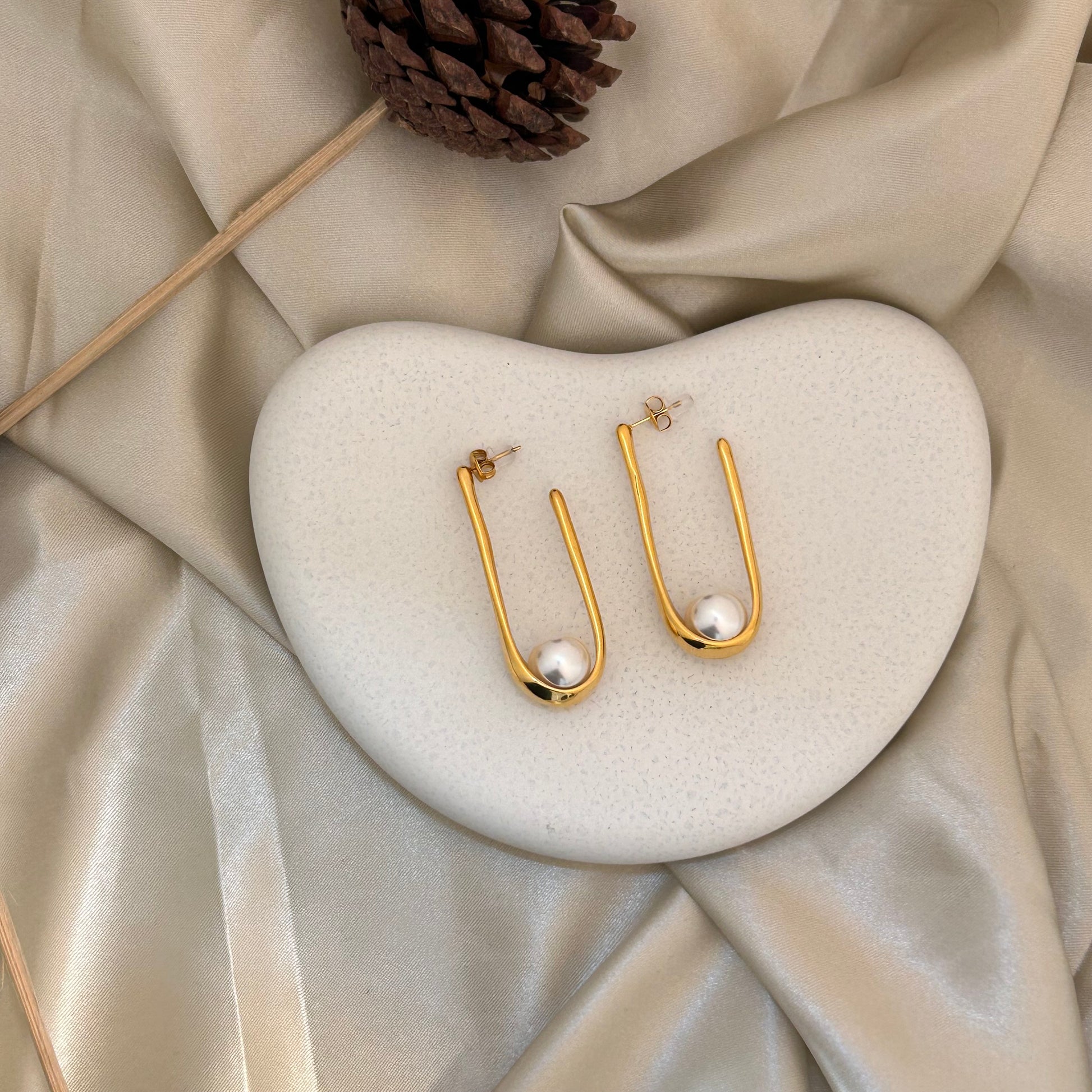 Gold-tone U-shaped hoop earrings with white pearl drops