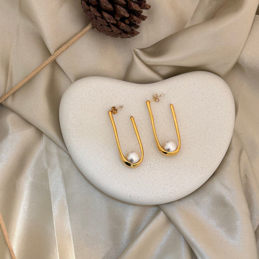 Gold-tone U-shaped hoop earrings with white pearl drops
