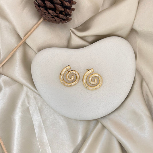 Gold spiral stud earrings with sparkling crystal pave swirl design