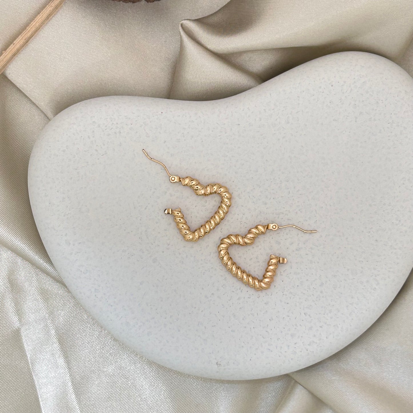 Gold-tone textured heart wrap hoop earrings with lever hooks, angled view