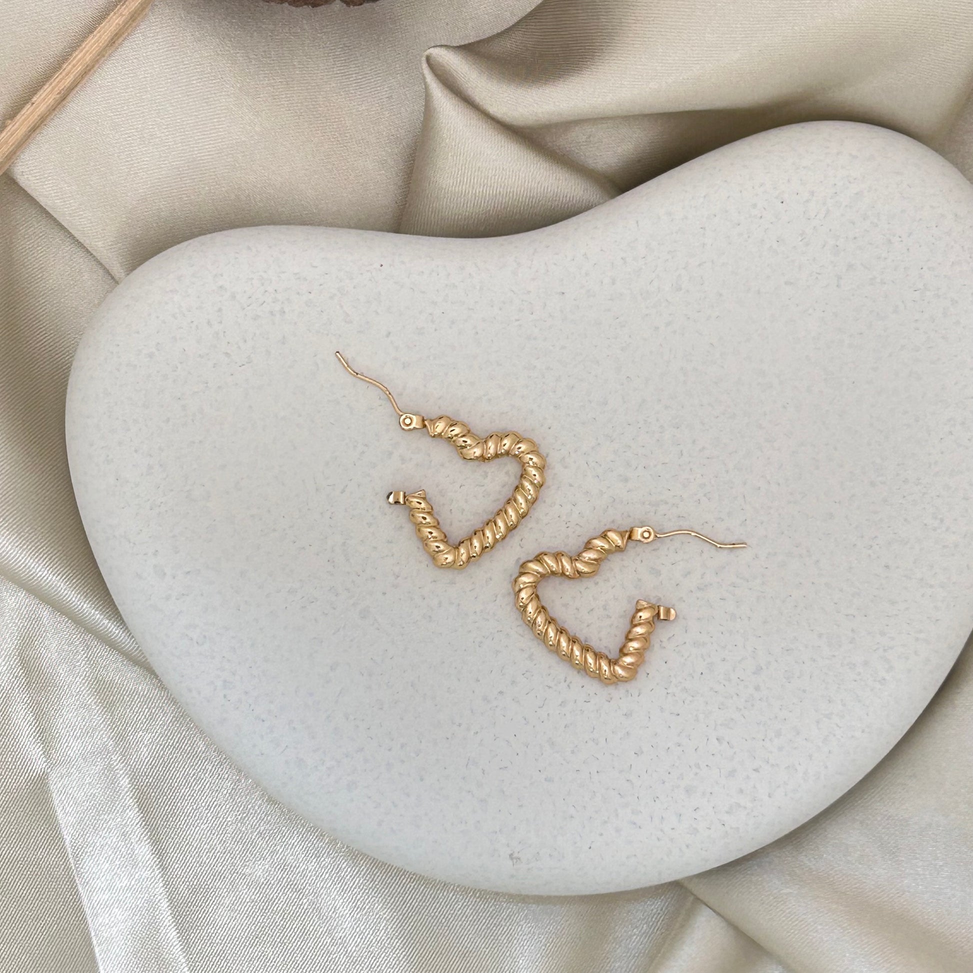 Gold-tone textured heart wrap hoop earrings with lever hooks, angled view