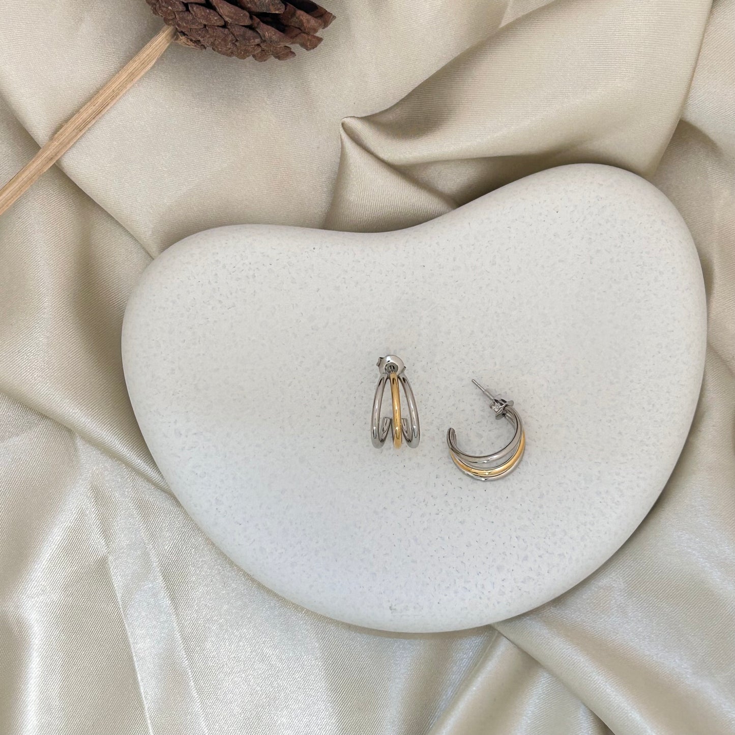 Bi metal triple hoop earrings with stacked silver and gold rings, front view