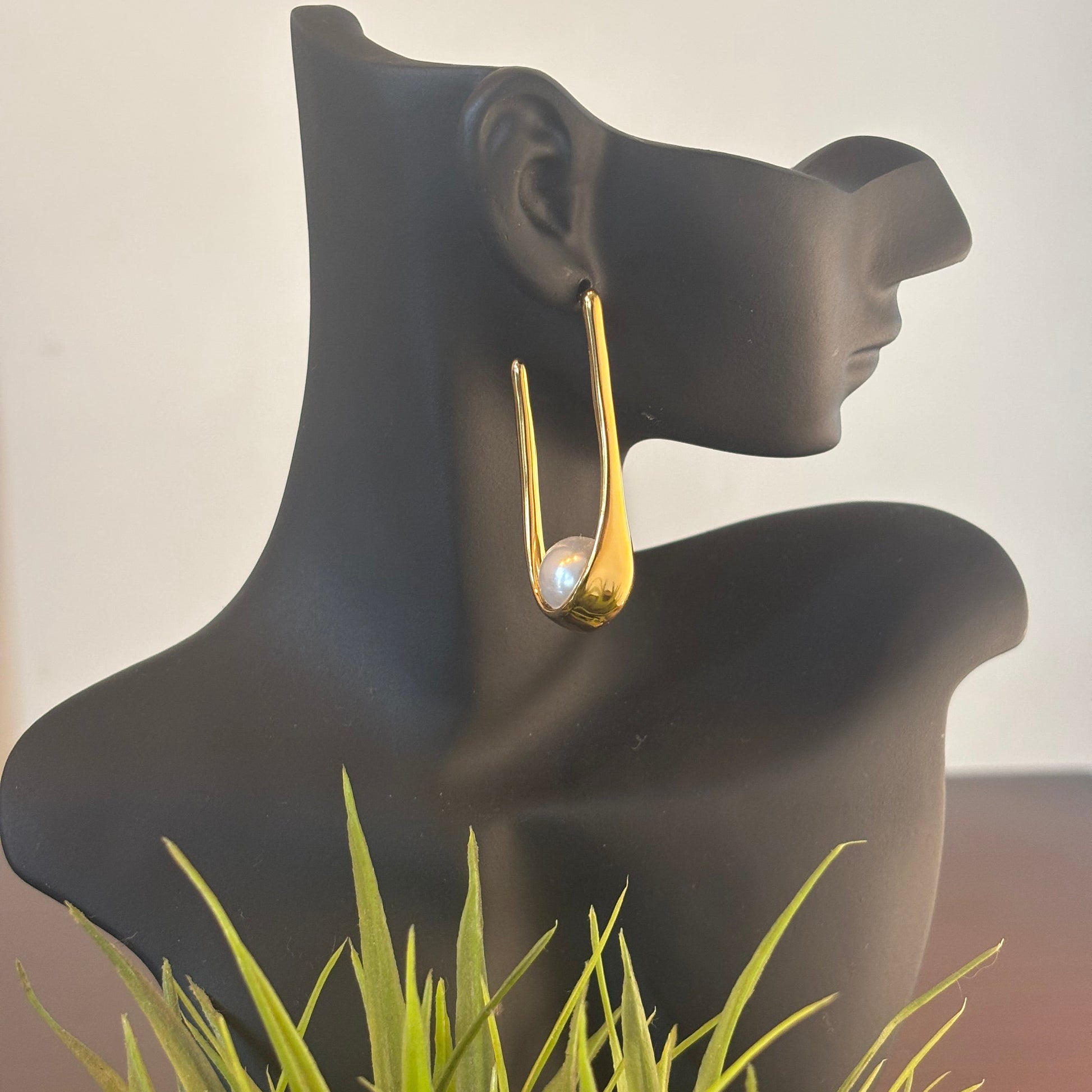 Gold-tone hoop earrings with white pearl set in curved frame