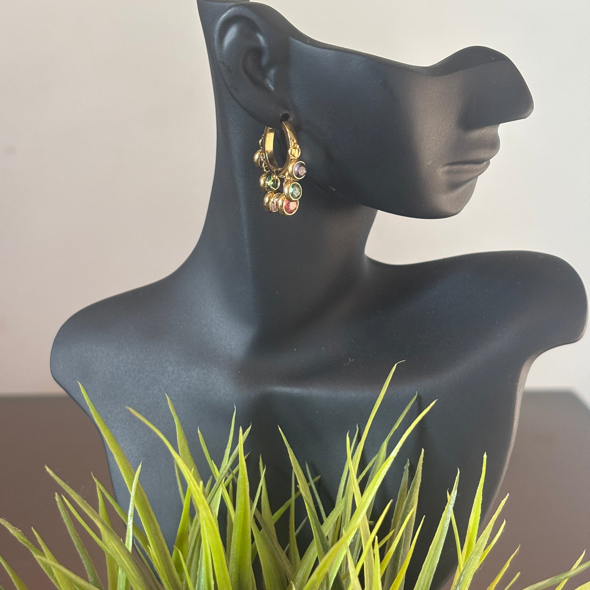 Gold hoop earrings with dangling multicolor beads and small charms