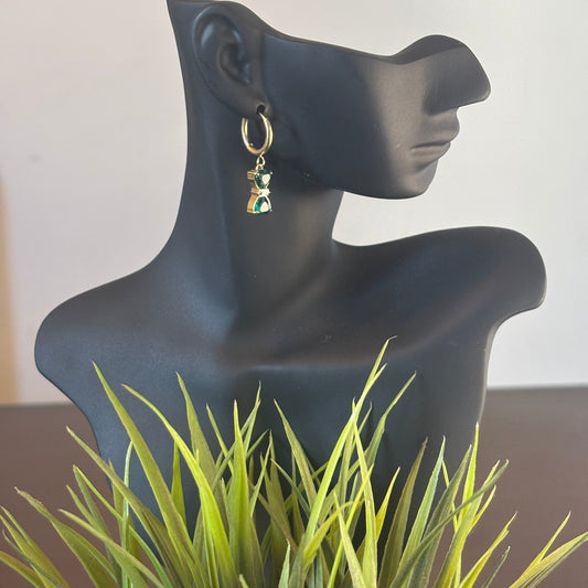 Gold hoop earrings with green bow-style drop charms, dangling