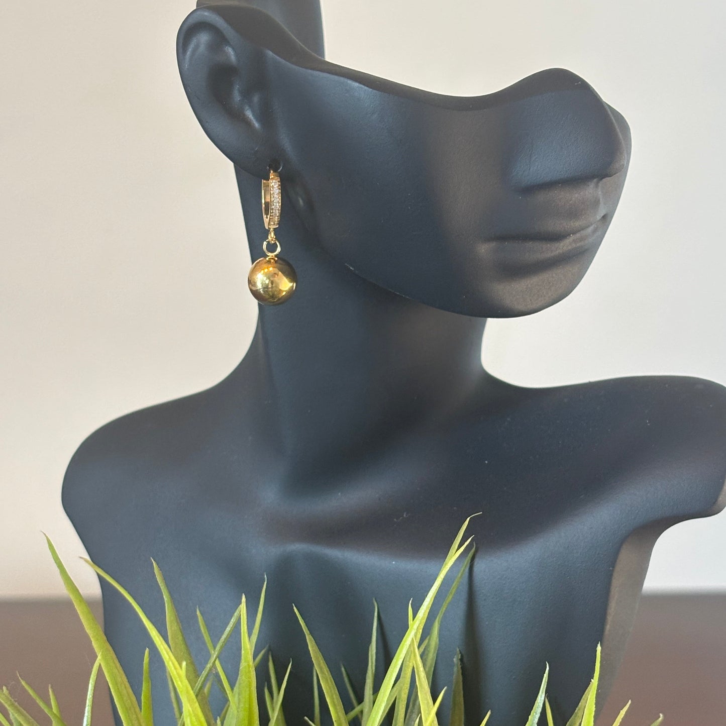 Gold ball drop earrings with hanging globe ball charms and crystal hoop detail