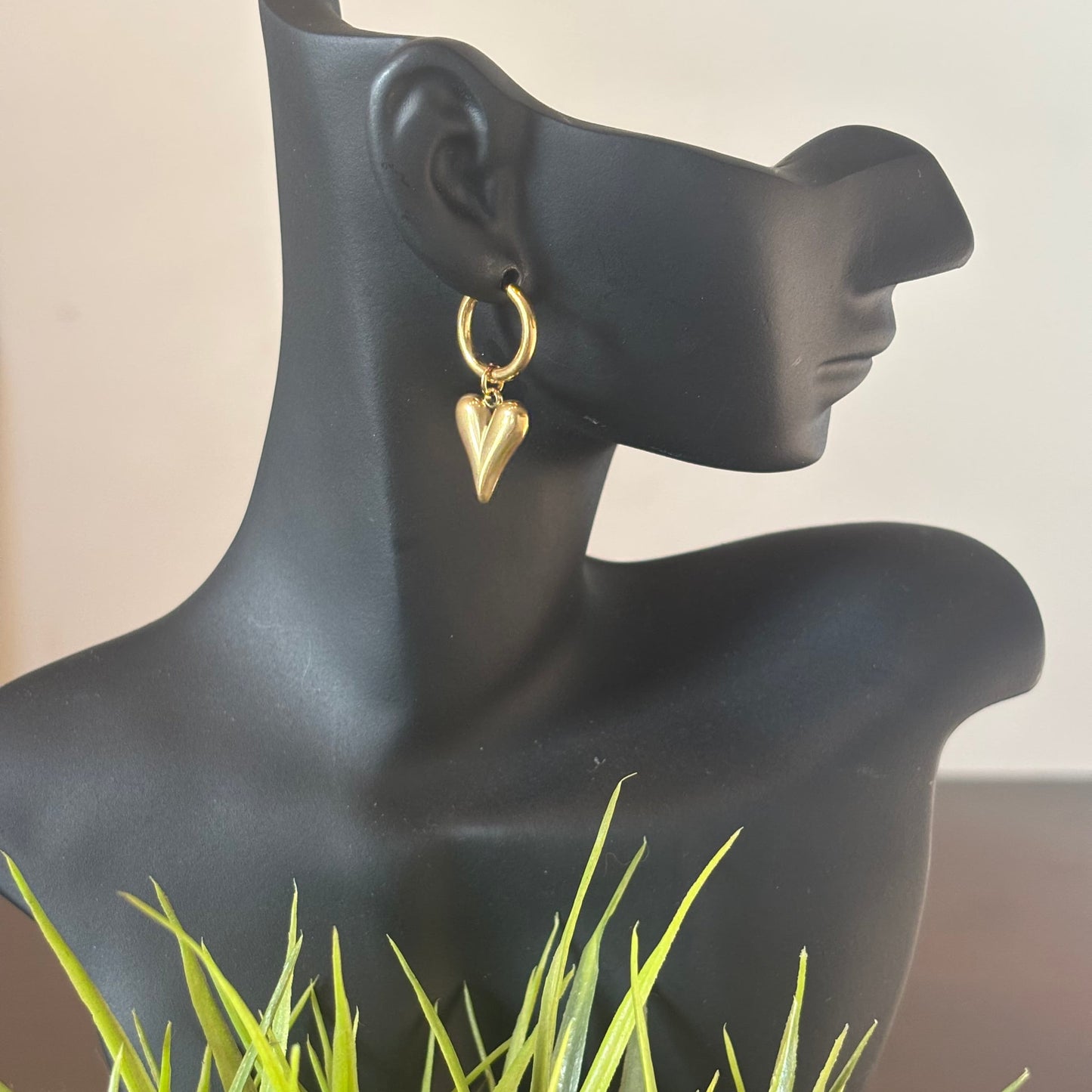 Gold-tone heart drop earring on hoop, hanging from a mannequin ear