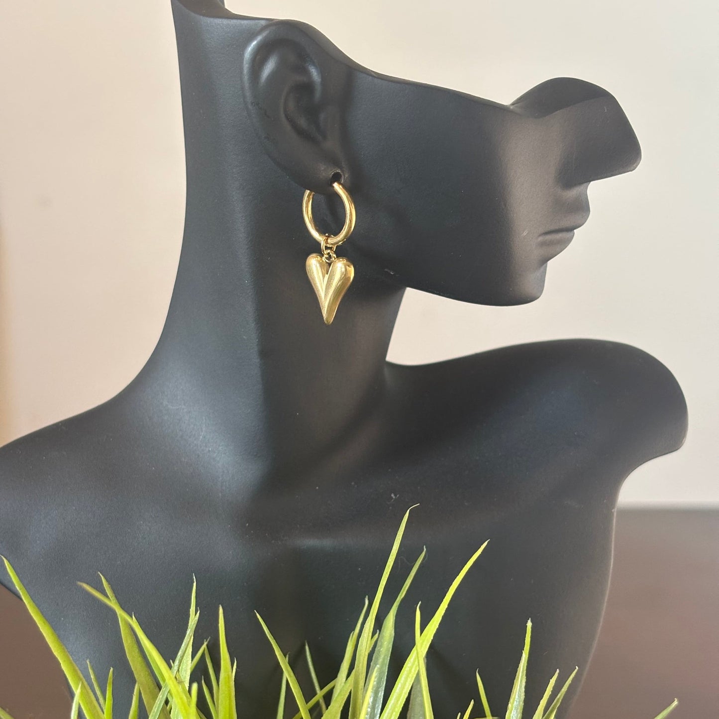 Gold-tone heart drop earrings with hoop hook, shown on a mannequin