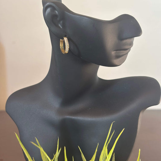Gold crystal-studded huggie hoop earrings on mannequin ear