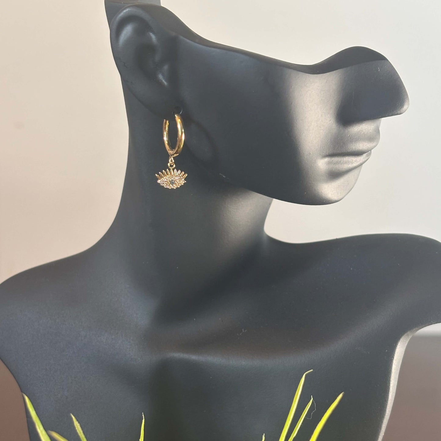 Gold huggie hoop earring with evil eye charm dangle and small blue eye center