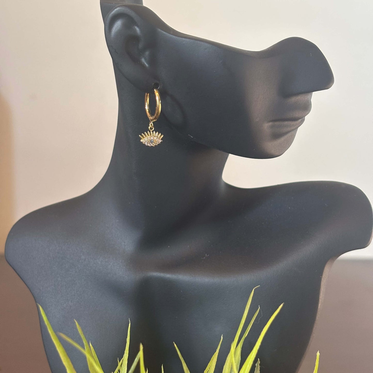 Gold huggie hoop earring with evil eye charm, small blue eye center on the drop