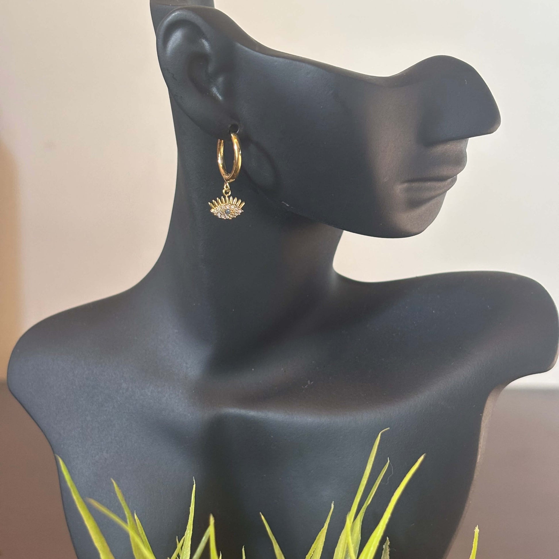 Gold huggie hoop earring with evil eye charm, small blue eye center on the drop