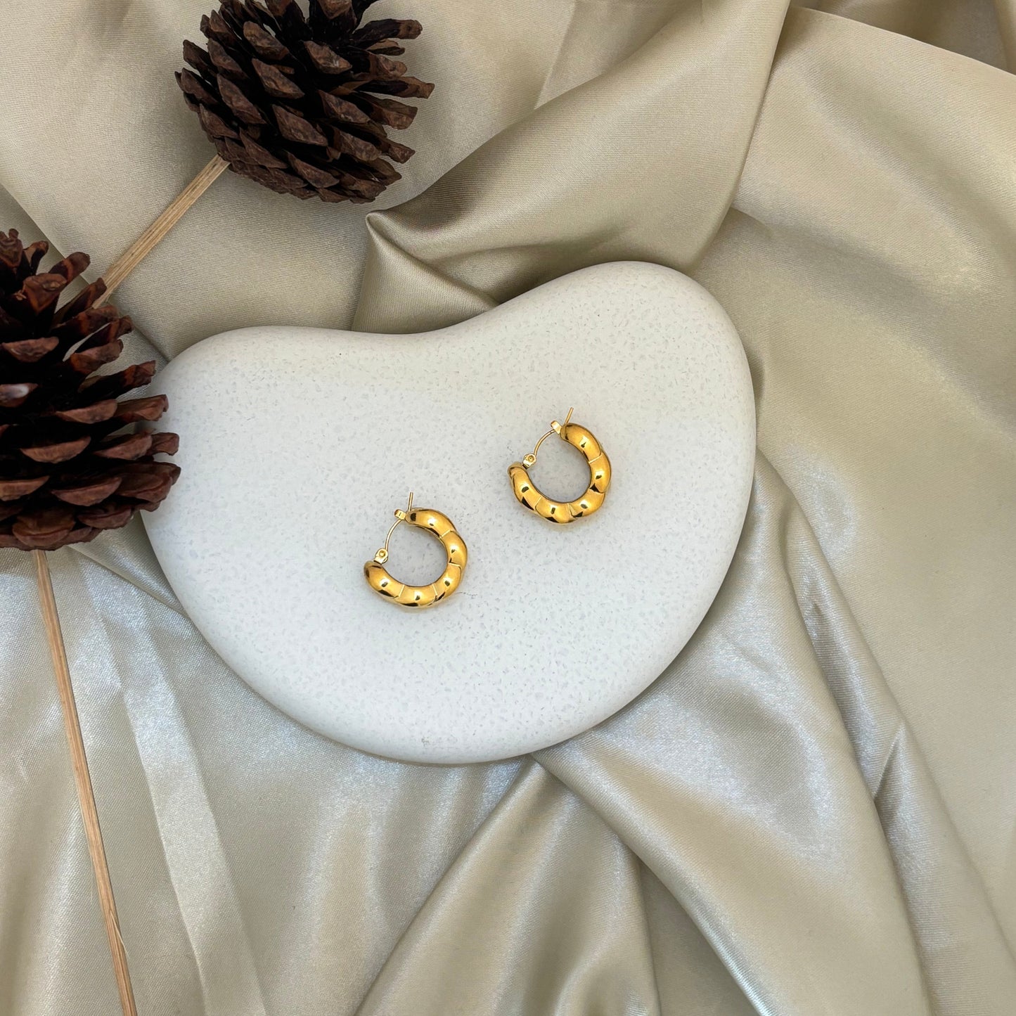 Gold chunky hoop earrings with textured segments and open circle design