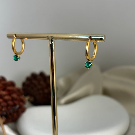 Gold hoop earrings with green drop charm on a vertical metal bar