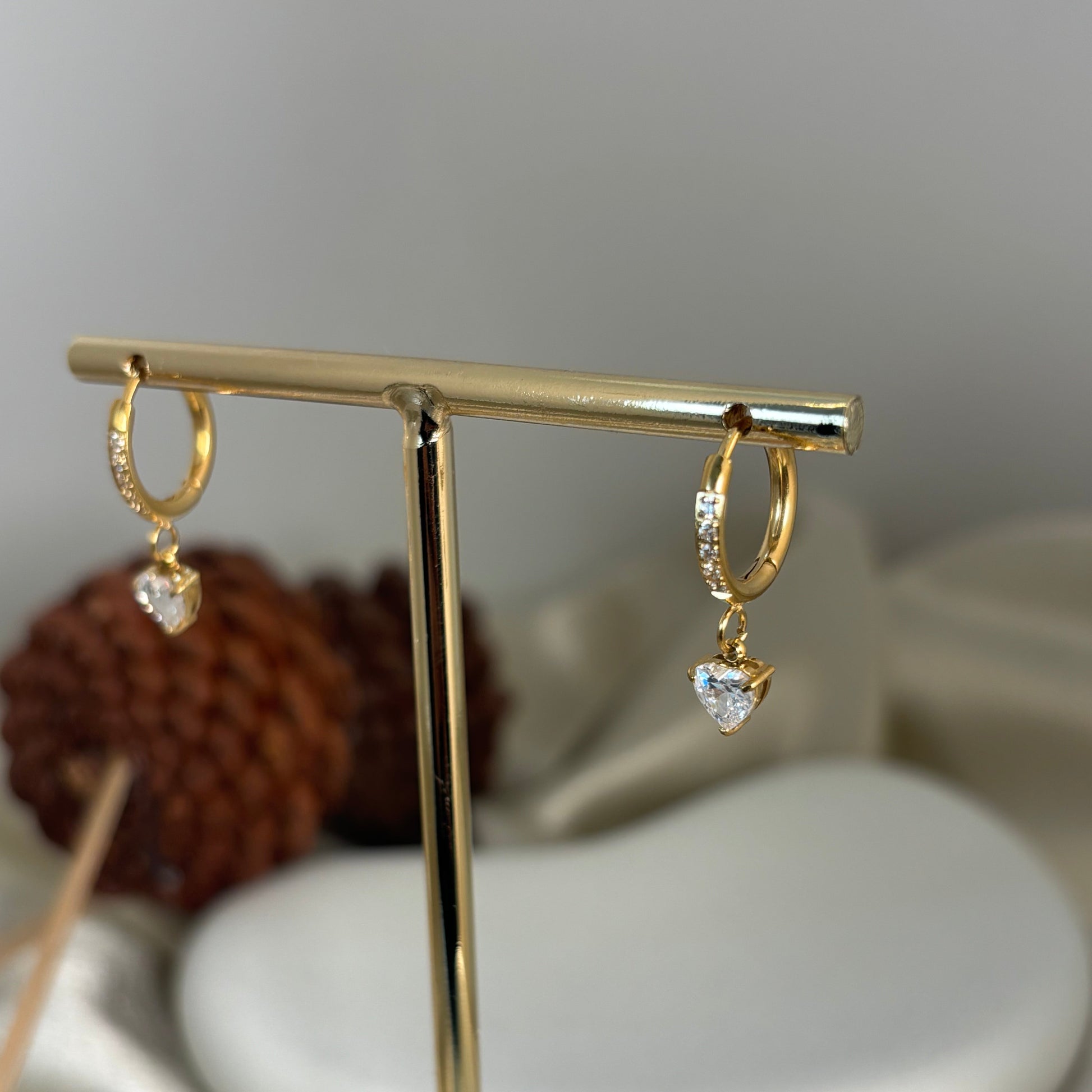 Gold heart drop earrings on bar display: hoop loops with crystal heart pendants