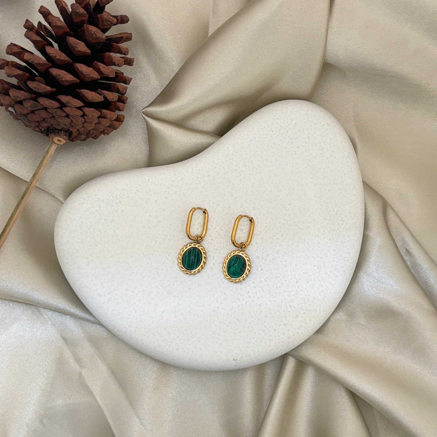 Pair of gold-tone drop earrings with green oval cabochon stones in decorative frames