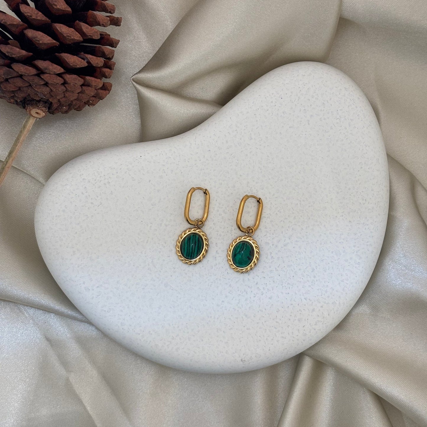 Gold-tone oval drop earrings with green cabochon stones, set on small hinged hoops