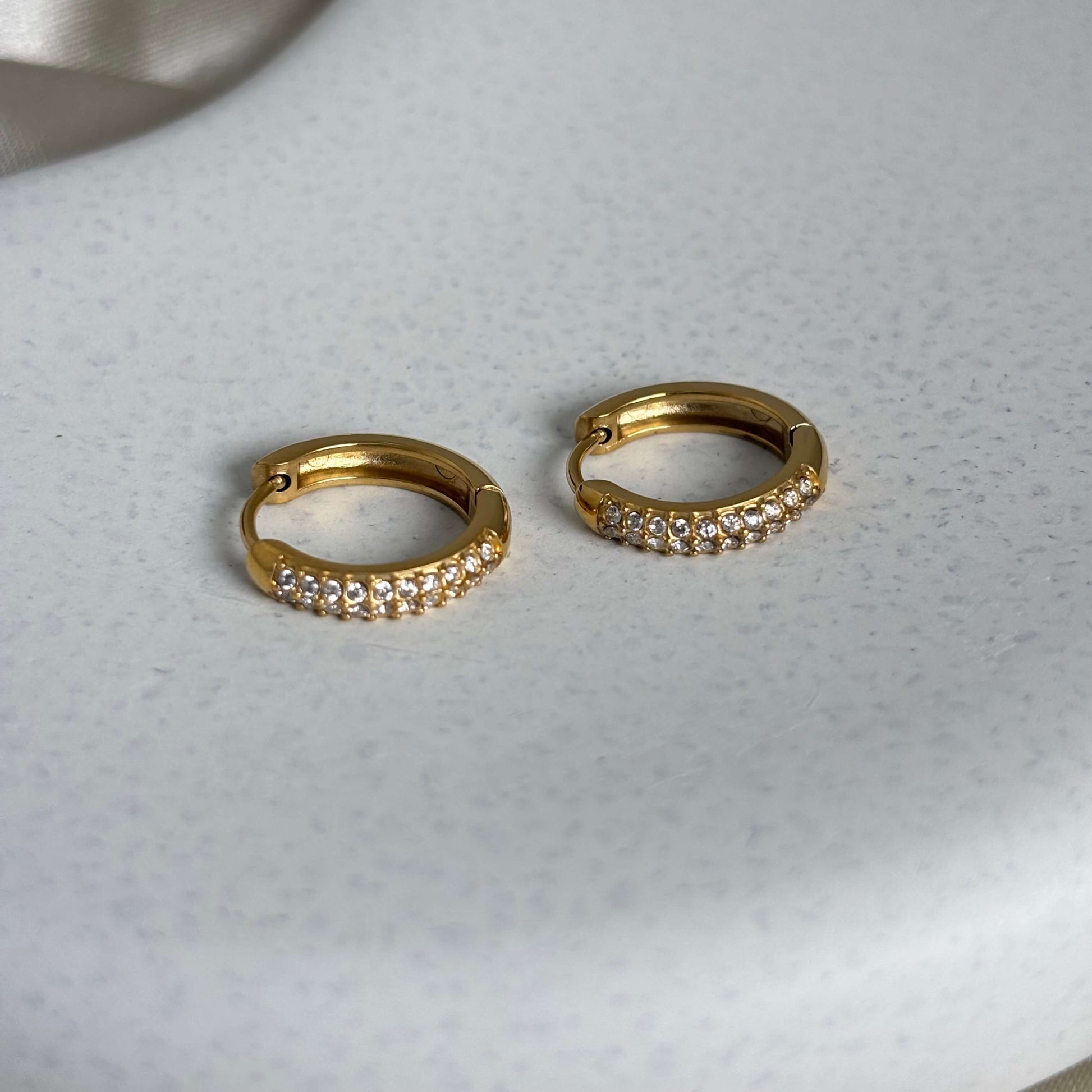 Gold huggie hoop earrings with crystal-studded front row
