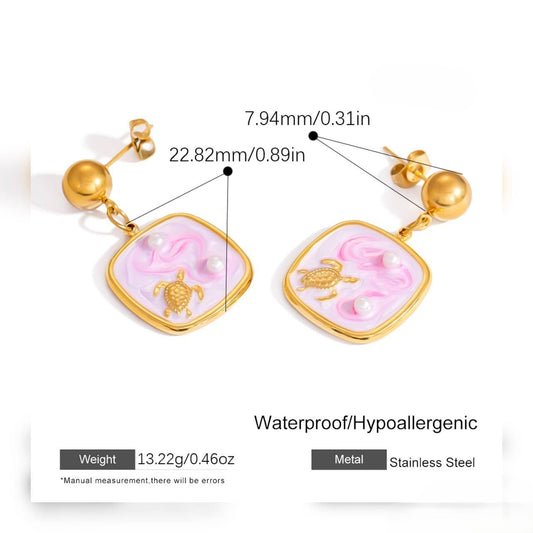 Pair of gold hoop earrings with square pink turtle charms and pearl accents